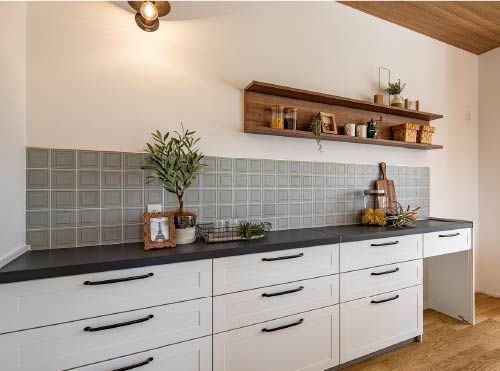 シンプルな白いキッチンは、天板と取っ手の黒がアクセントに。
