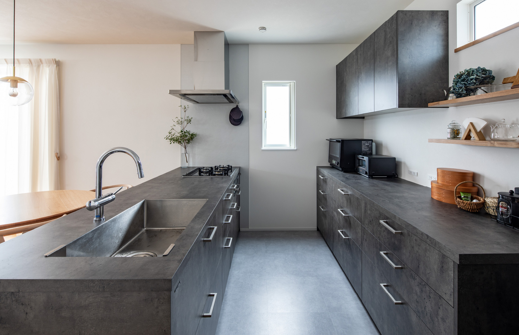 奥様が気に入っているキッチンは家電を黒で統一し、木製の棚には厳選したインテリア雑貨を並べた。背面も合わせると収納量はたっぷり。