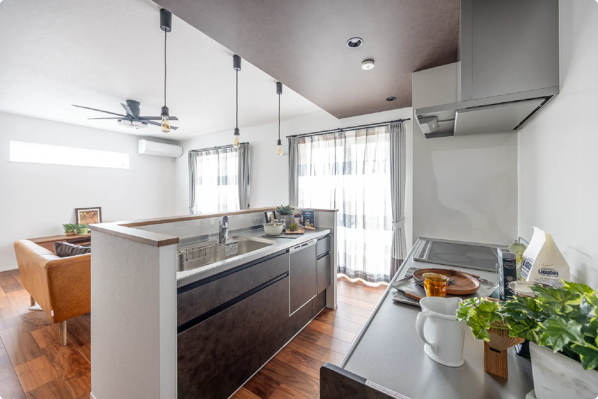 南側に設けられた2枚の掃き出し窓からは明るい日差しが差し込みます。下がり天井でアクセントをつけることで、キッチンを特別に色付けます。