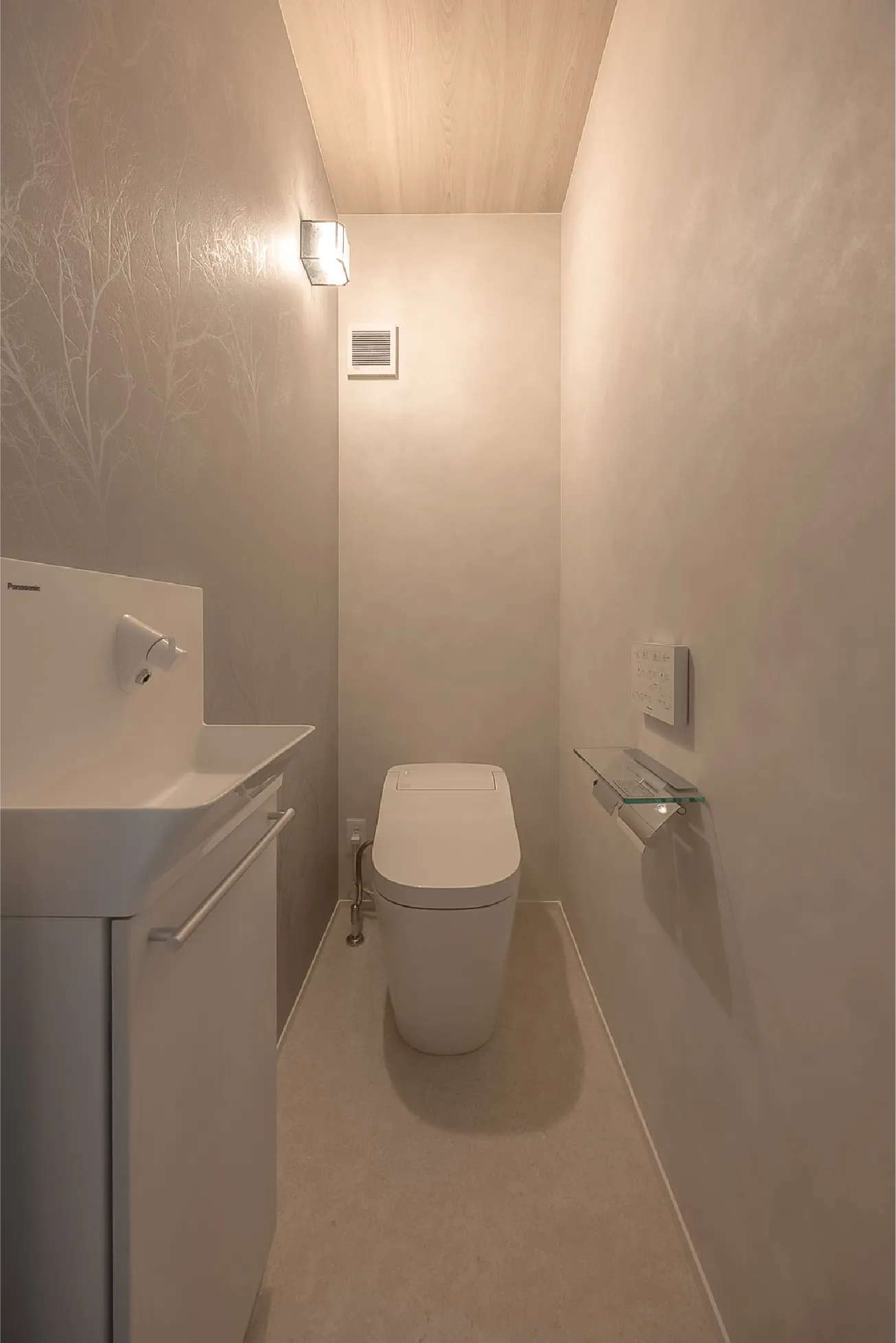 トイレは光が当たると柄が浮かび上がるクロスを採用。天井は木目調にし、高級感のある空間に仕上げました。