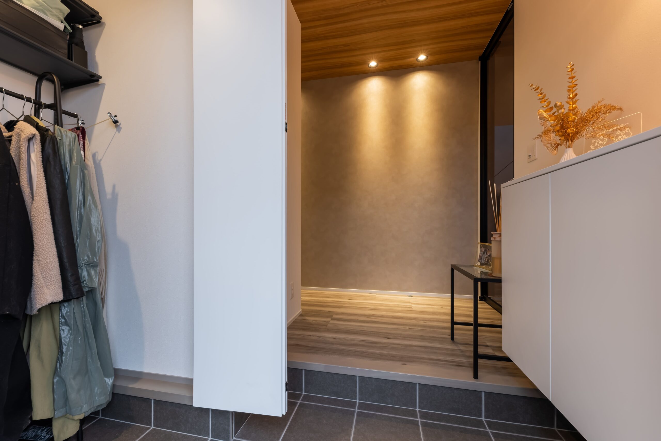 玄関には上着類をたっぷりかけられるシューズクロークを用意。ホールにキッチンと同じ木の下がり天井を配し、LDKとのつながりをもたせた。
