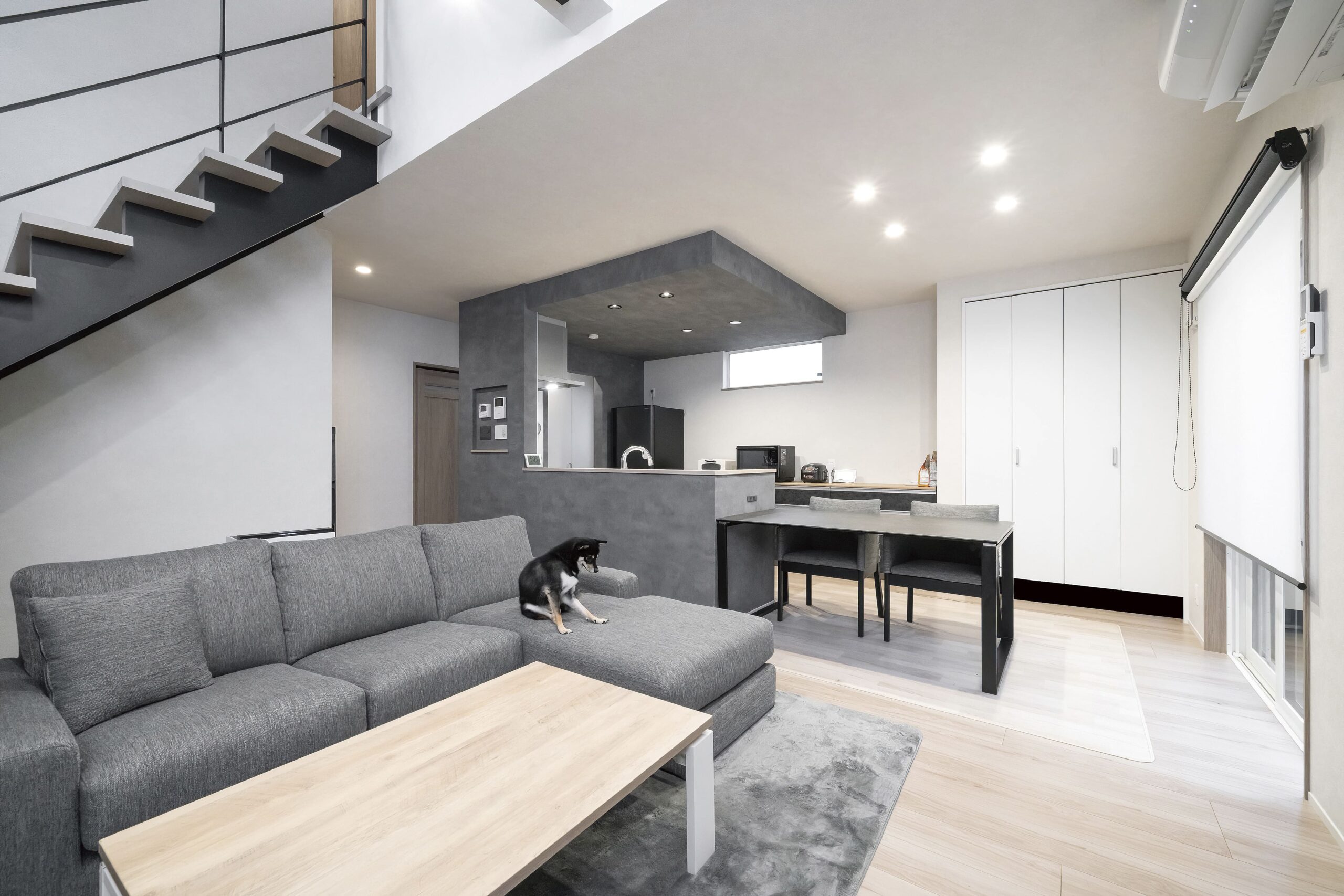 家の中はモノトーンでコーディネートされたモダンな空間。妻Tさんの要望を反映させたキッチンは、ダイニングテーブルと横並びなうえ、パントリーや洗面所へもすぐに行ける効率的な回遊動線を実現。空間にメリハリをつける下がり天井がおしゃれな印象を添える。収納も豊富に用意されている。