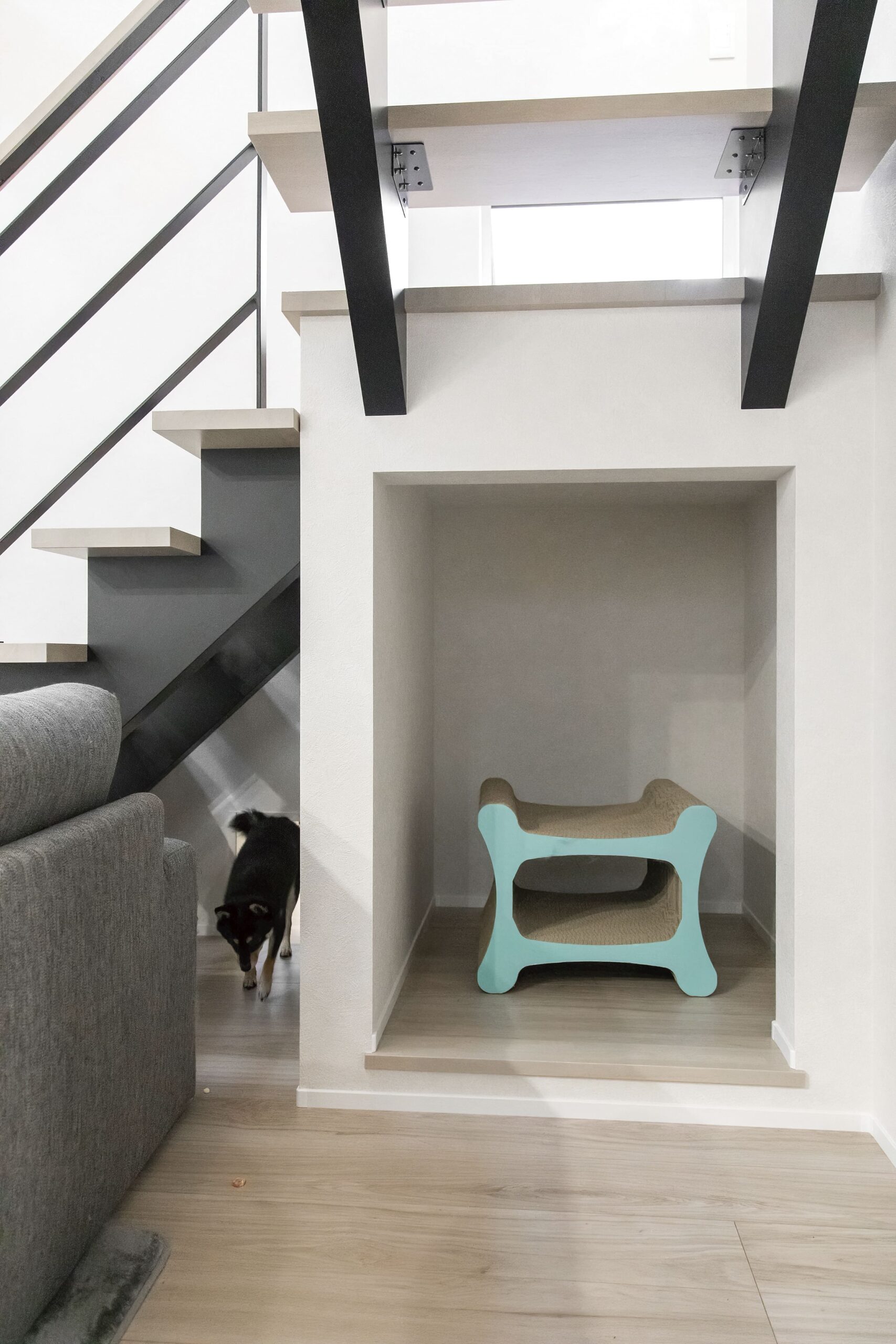 「猫用のトイレを設けるスペースを」と作った階段下の空間には大きな爪とぎが。インナーテラスの壁に設けたくぐり戸は、ワンちゃんも通れる大きさ。