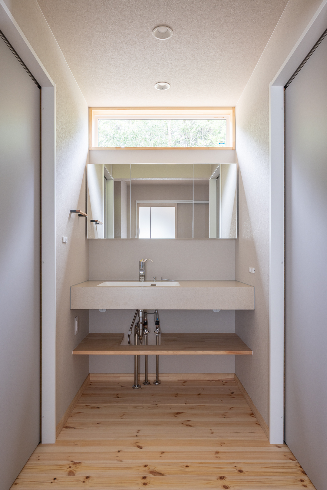 高窓から光が入る明るい洗面所。幅広のカウンターと大きな三面鏡で、朝の支度もスムーズに行えます。