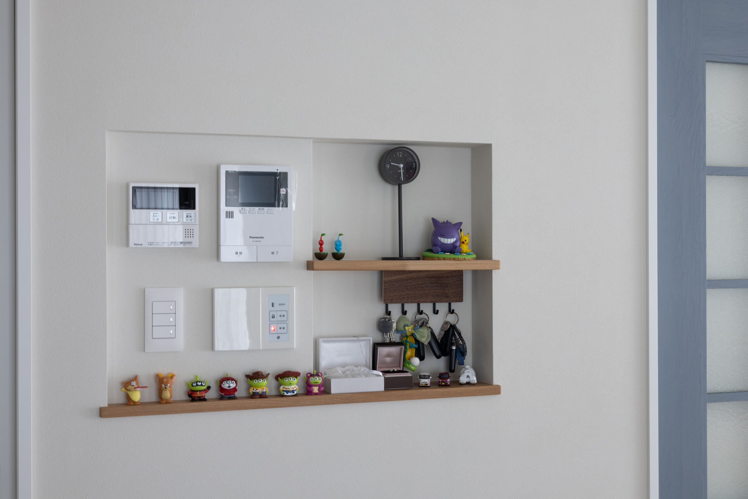 スイッチやインターホンをまとめたニッチ。お気に入りの小物も飾れる棚で、便利さと遊び心を両立しました。