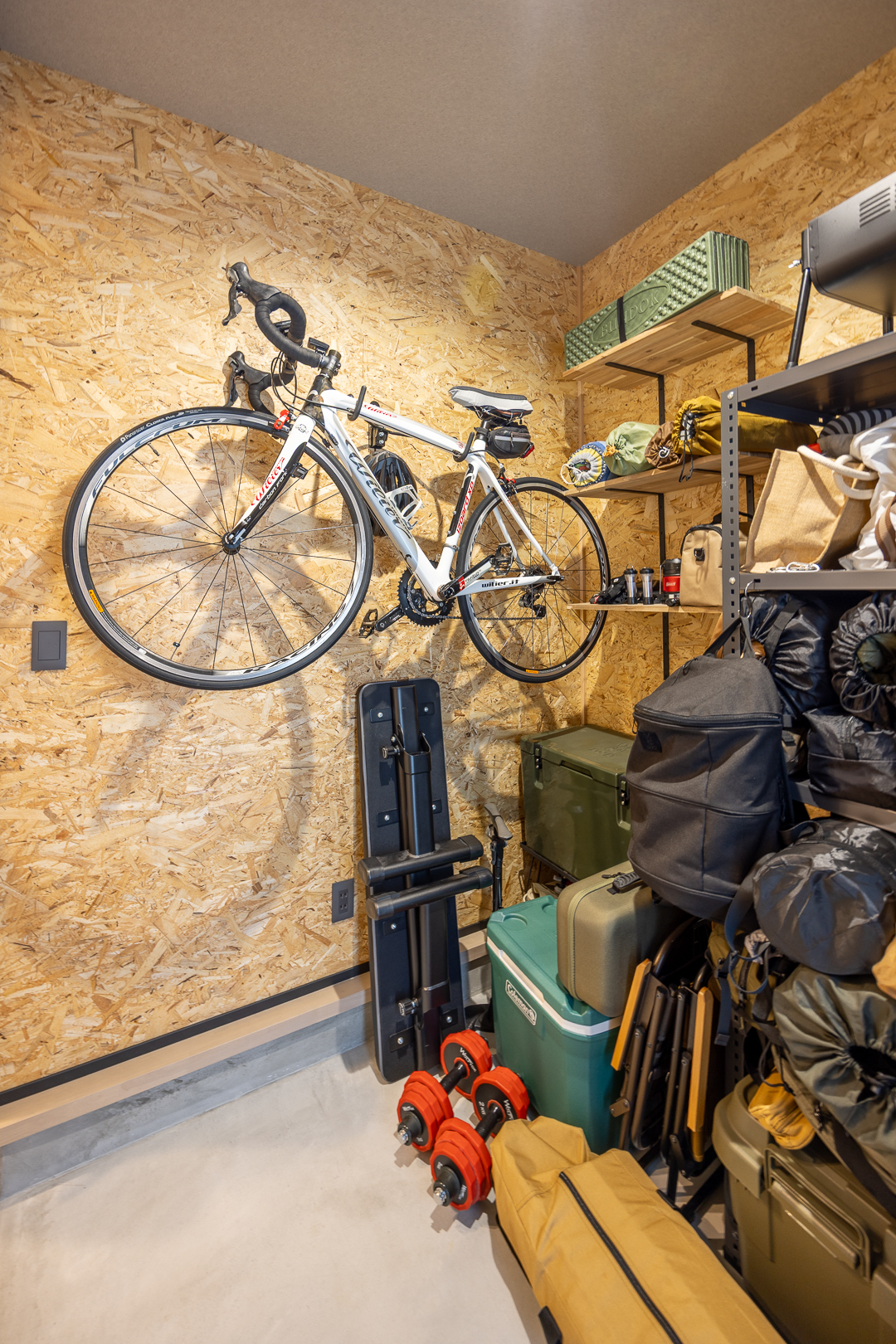 ご主人がDIYで完成させたアウトドアストッカー。自転車やアウトドア用品をすっきり収め、趣味を存分に楽しめる。