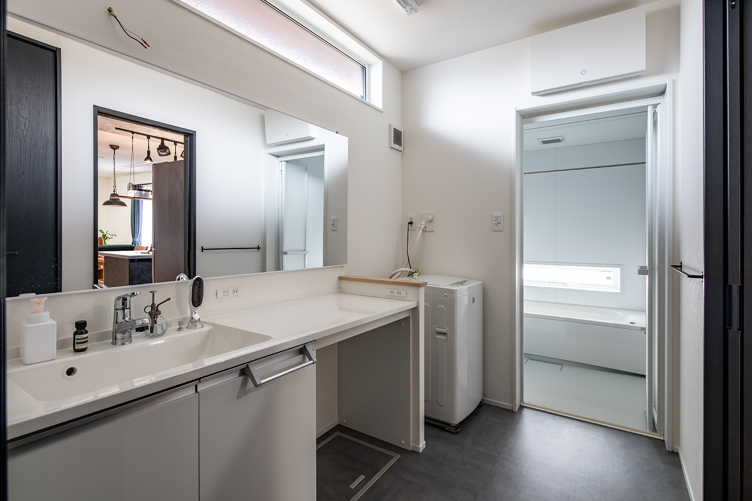 洗面台は家族が一度に立てるように、横長の鏡をH様が探して設置。メイクができるスペースを備えたパナソニック製を採用した。