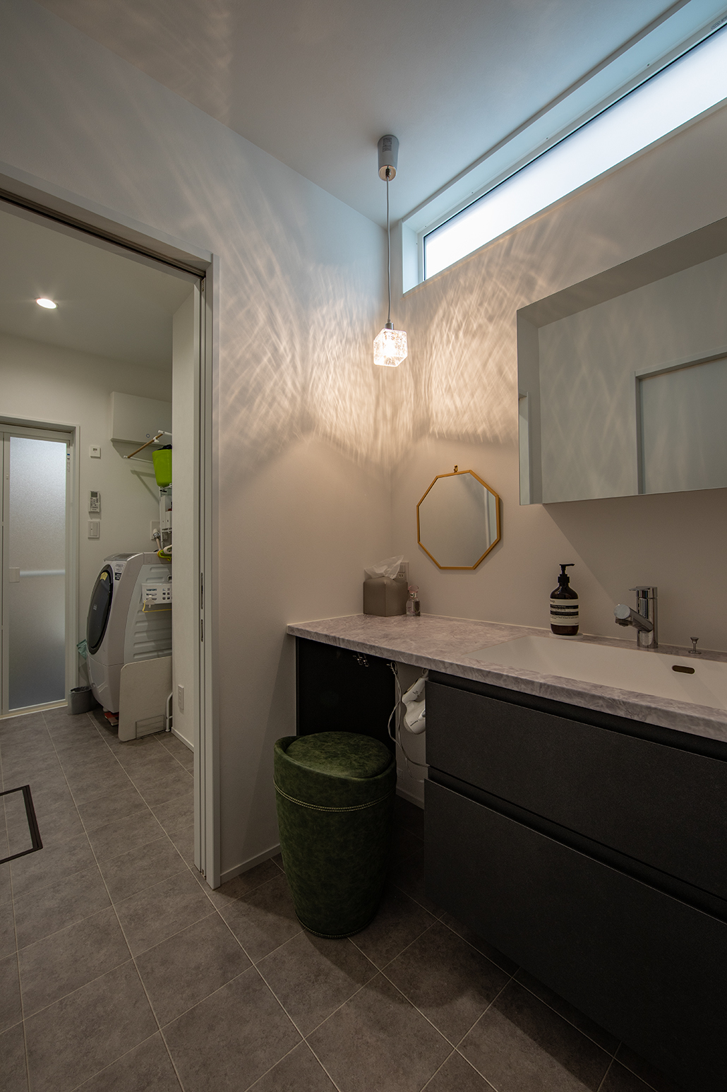 椅子に座ってゆっくりメイクができる大理石風の洗面台。鏡も大きめのものを選んだ。