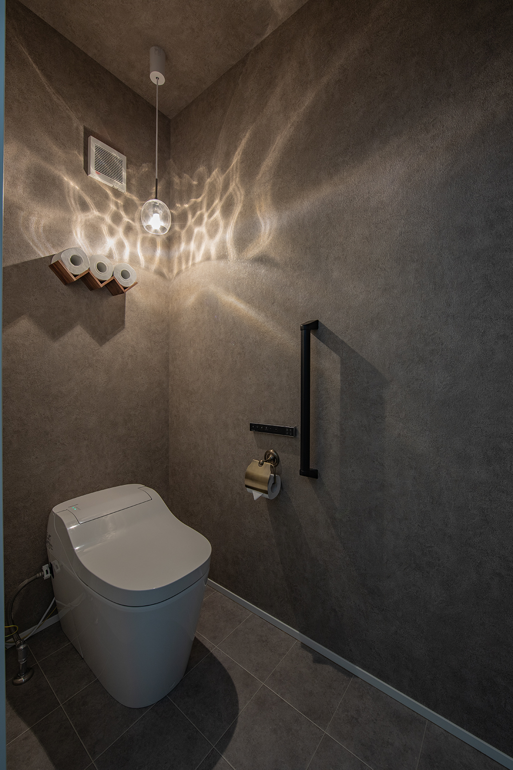 白を基調にした室内とは打って変わってトイレはシックに。ペーパーホルダーは自分たちで探した。