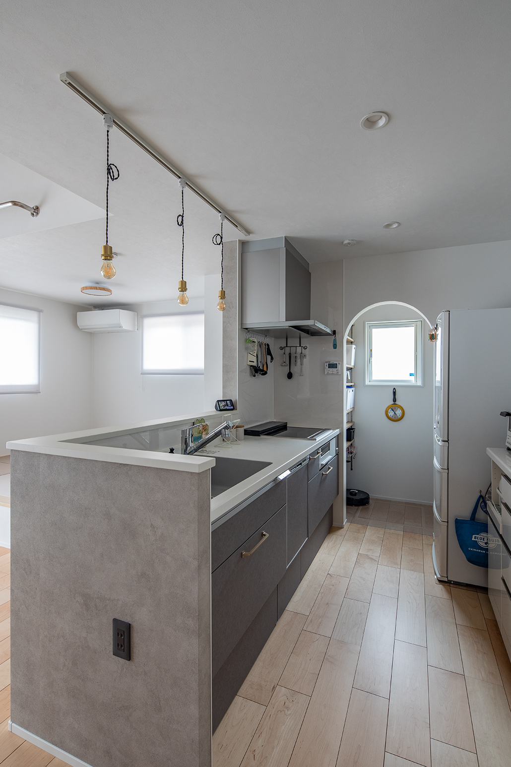 手元が隠せるように立ち上がりをつけた対面キッチン。奥のパントリーにキッチン家電やお掃除ロボを収納。