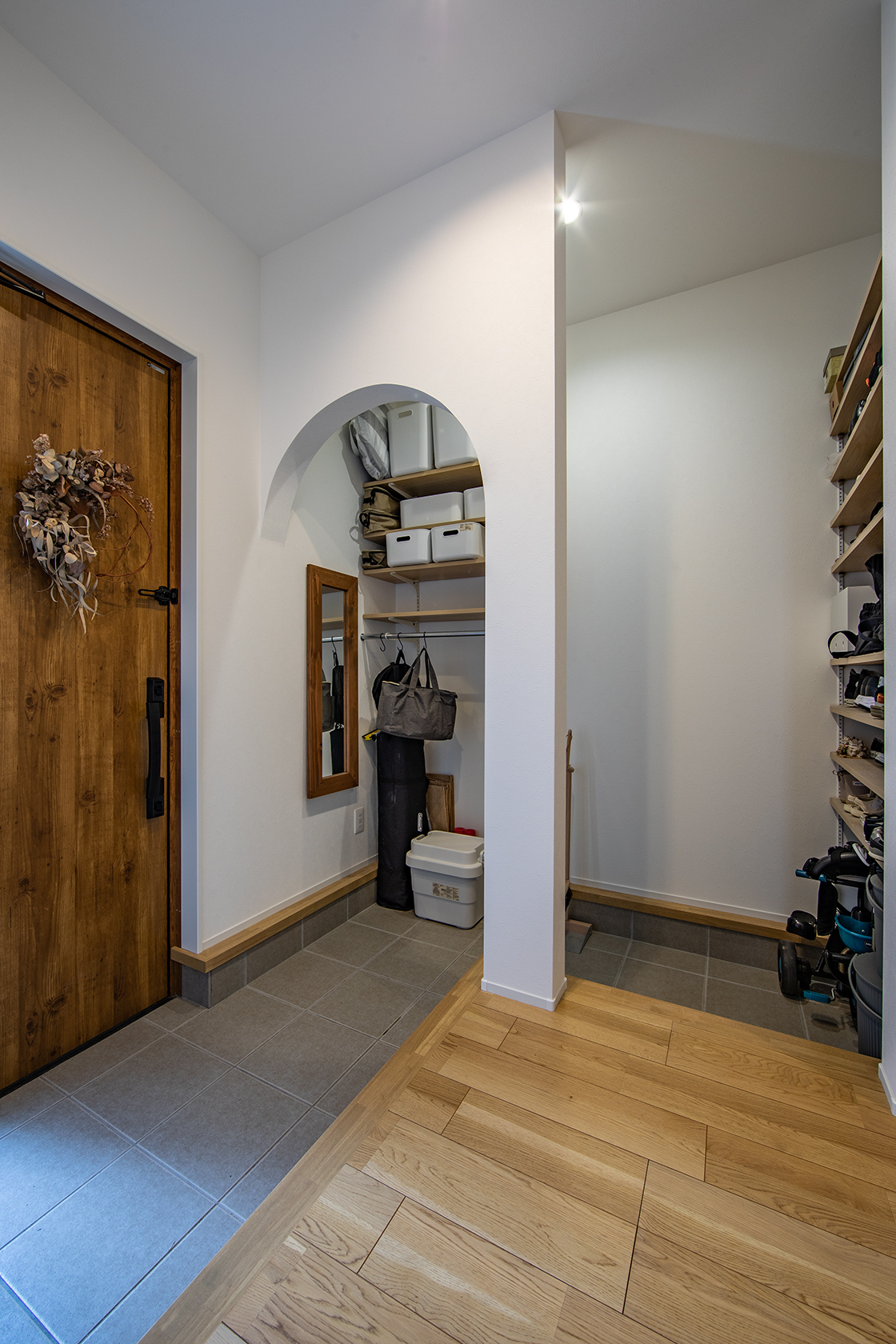帰宅した家族はアーチ壁を通りシューズクロゼットで靴を脱ぎ室内へ。そうすることで玄関に靴が散らばらず、すっきりと保てる。