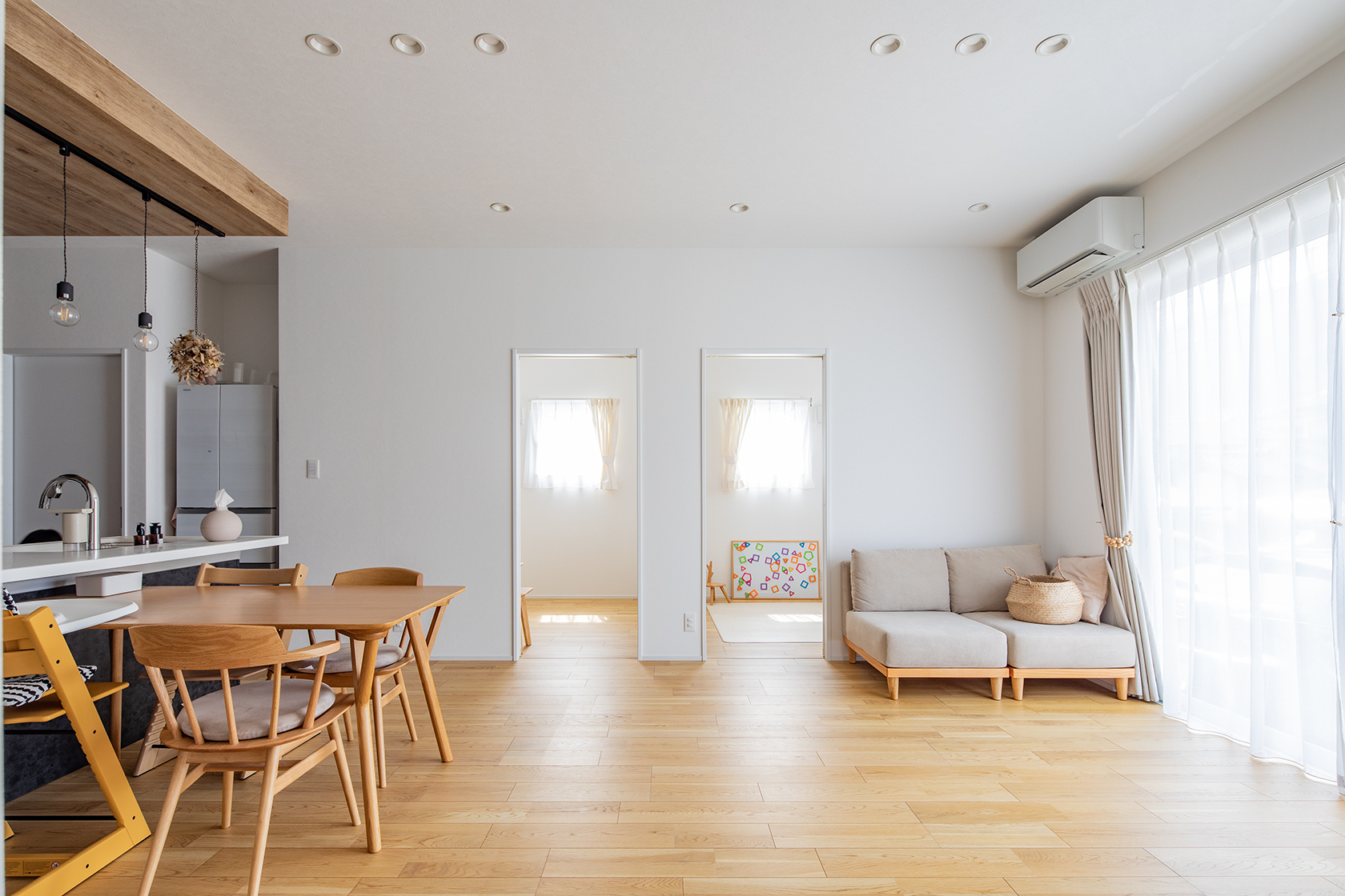 大きな窓と高い天井によって開放感を得たリビング。遊んでいる様子が分かるようにリビング横につくった子ども部屋。将来大きくなった時、家族とのコミュニケーションが取りやすい。