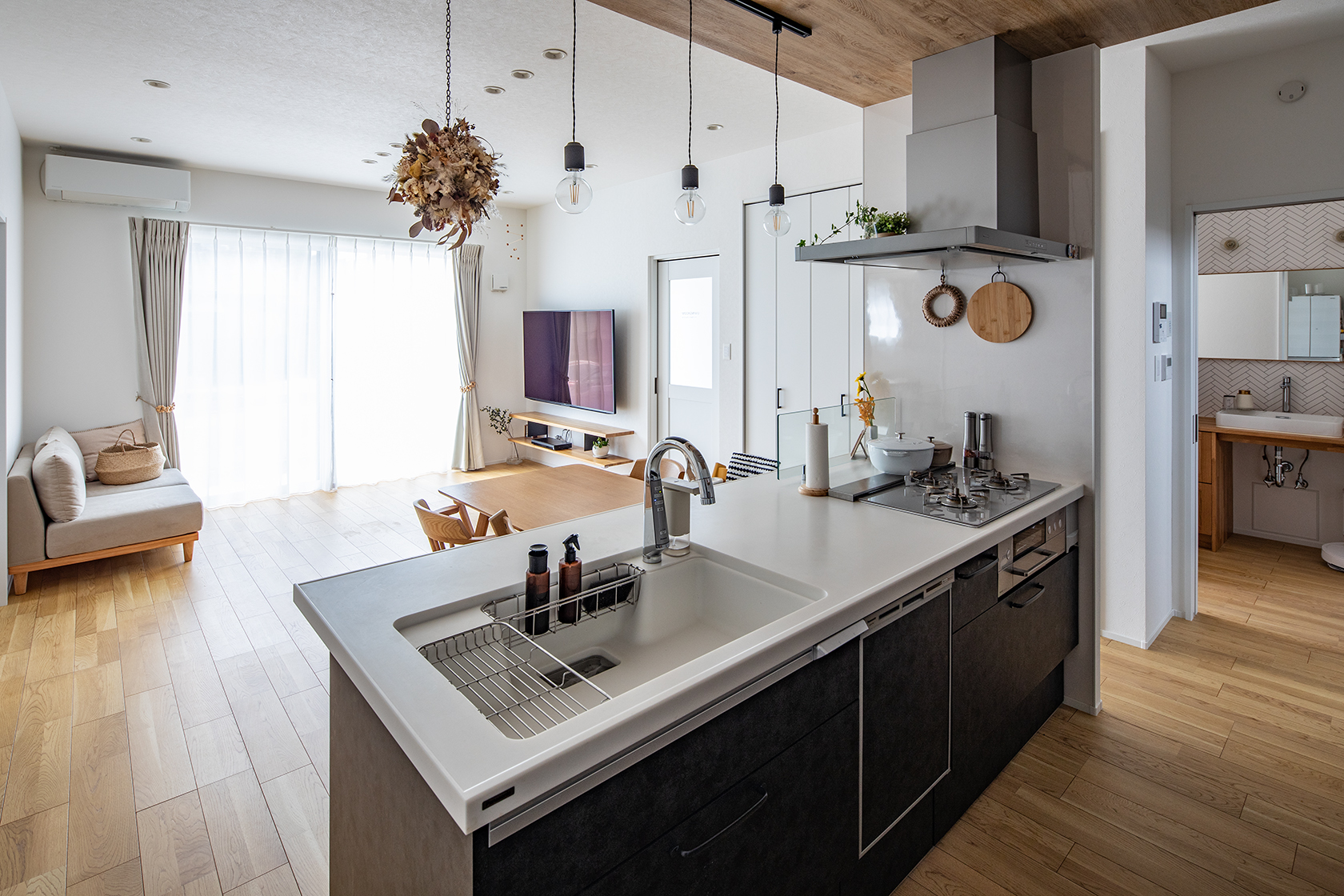 キッチンに立った時、窓の外の景色やリビングで遊ぶ子どもたちがよく見える対面式にした。あえて立ち上がりをつけず、配膳のしやすいフラットタイプに。