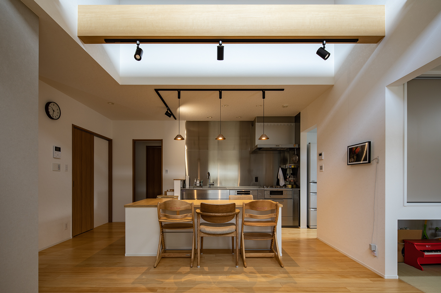 Ｌ字型のカウンターテーブルは毎日使う食器や箸を収納できるように造作した。脱衣室などの水回りにキッチンから行きやすいよう、カウンターの一部を跳ね上げ式にしている。