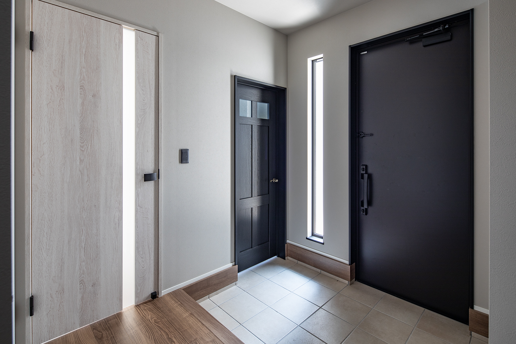 中央の黒いドアは土間へ、左はリビングへ