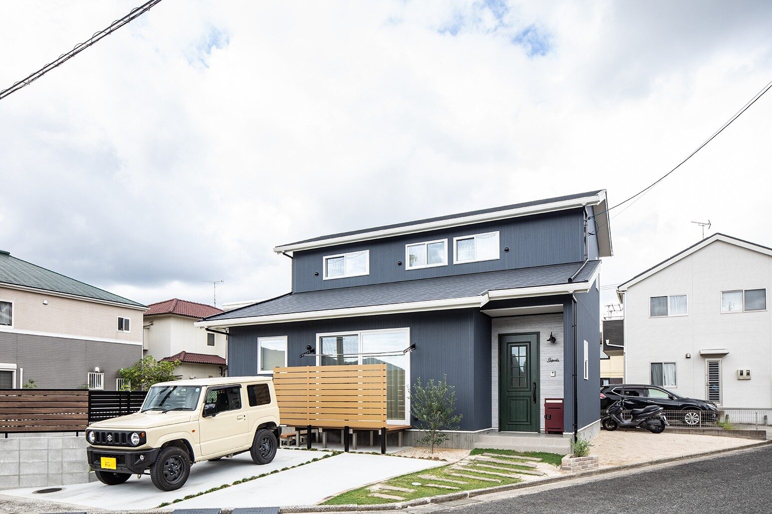 「おしゃれな上に汚れが目立ちにくいから」と選んだネイビーのサイディング。雨樋や窓枠を白にして爽やかなイメージに。