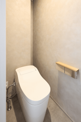 奥側に造作棚を設け、トイレットペーパーや掃除用品をすっきり収納可能に。無駄を省いたシンプルな空間ながら、暮らしやすさと清潔感を両立。