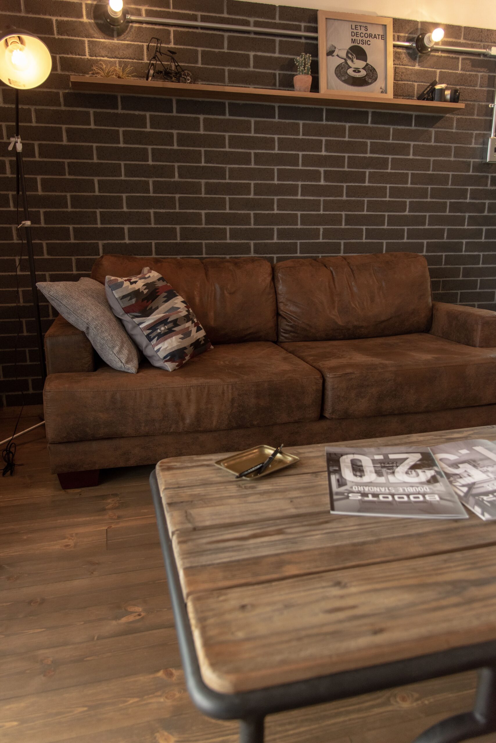 レンガと革ソファが映える、落ち着いたリビング空間。