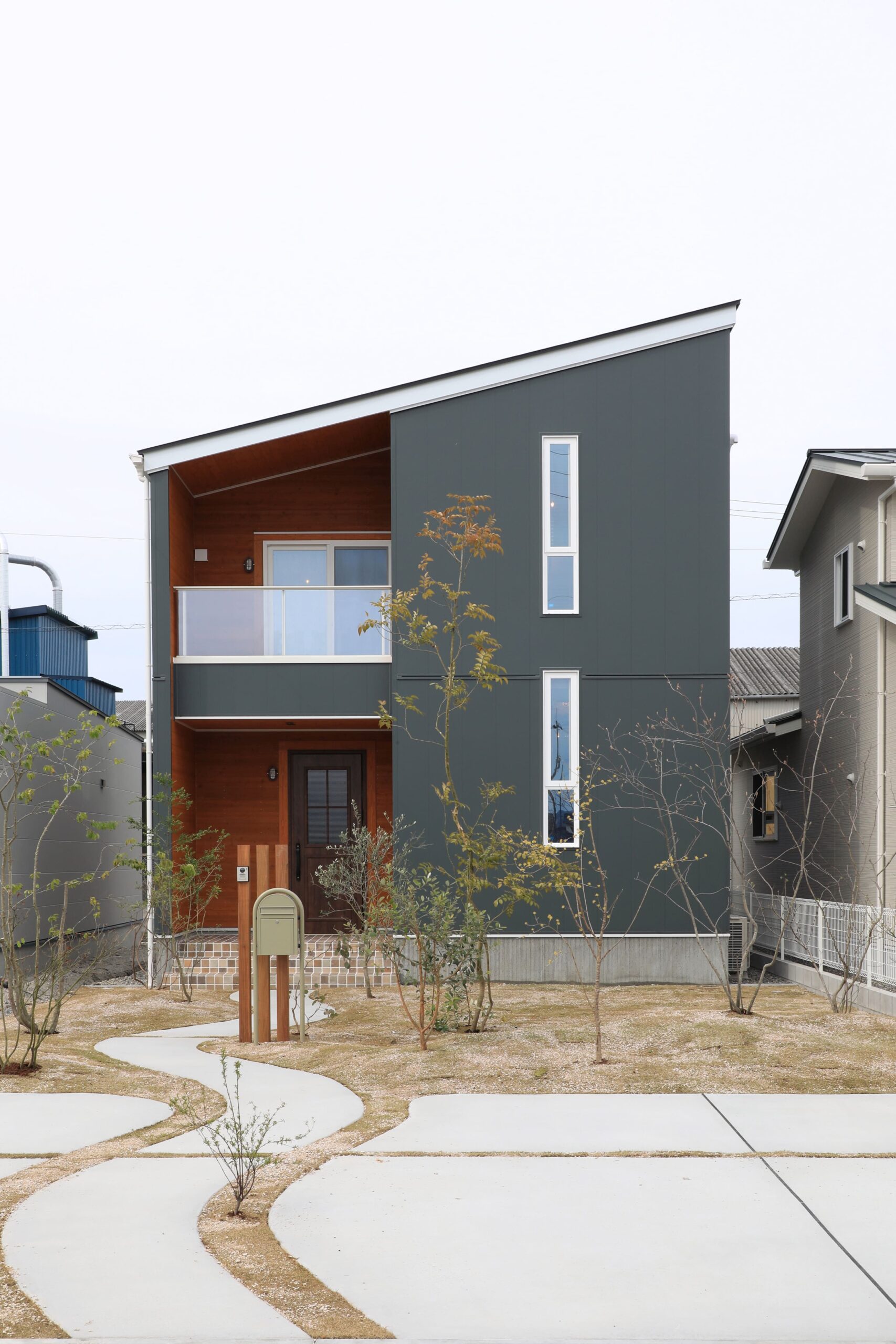 木目とモスグリーンの外壁が調和する、シンプルで洗練された外観デザイン。