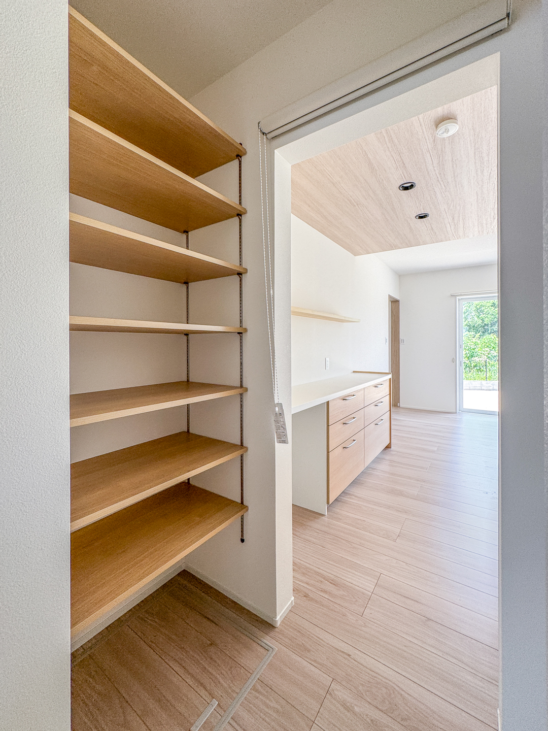 キッチン横に設けたパントリーは可動棚で高さ調整が自由。買い置きや調理家電をすっきり収められる。