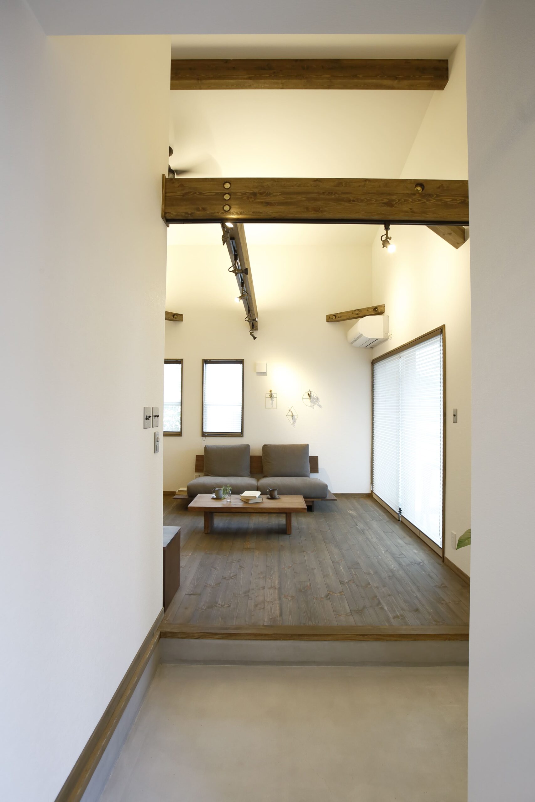 玄関の土間とリビングがひとつながりになった設計。段差を活かして空間をゆるやかに仕切りながらも、吹き抜けの天井と大きな窓が広がりを生み出し、開放感たっぷりの暮らしを実現します。