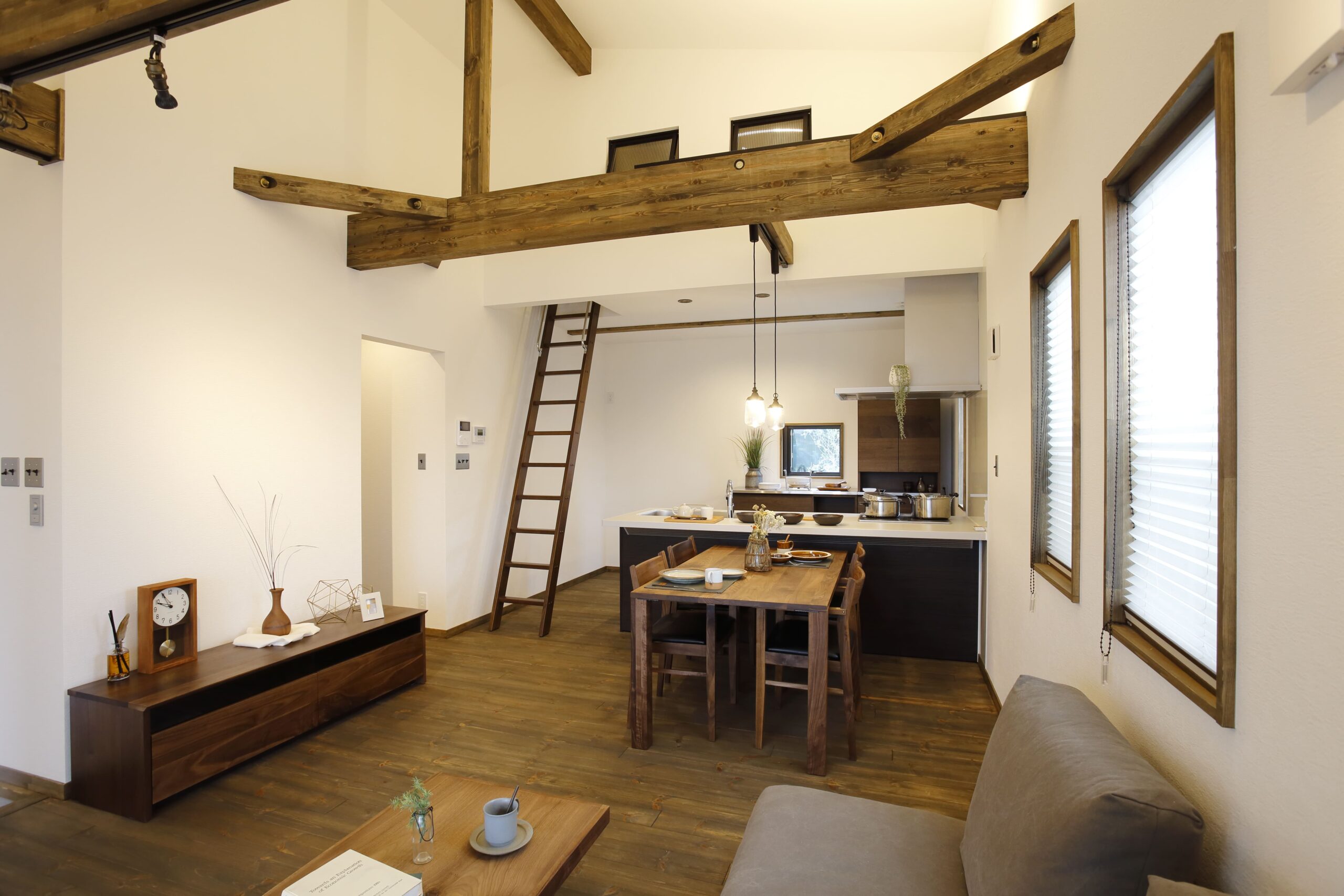 吹き抜けと化粧梁が印象的なリビング。自然素材の温もりに包まれた開放的な空間は、家族が集う居心地の良い場所に。