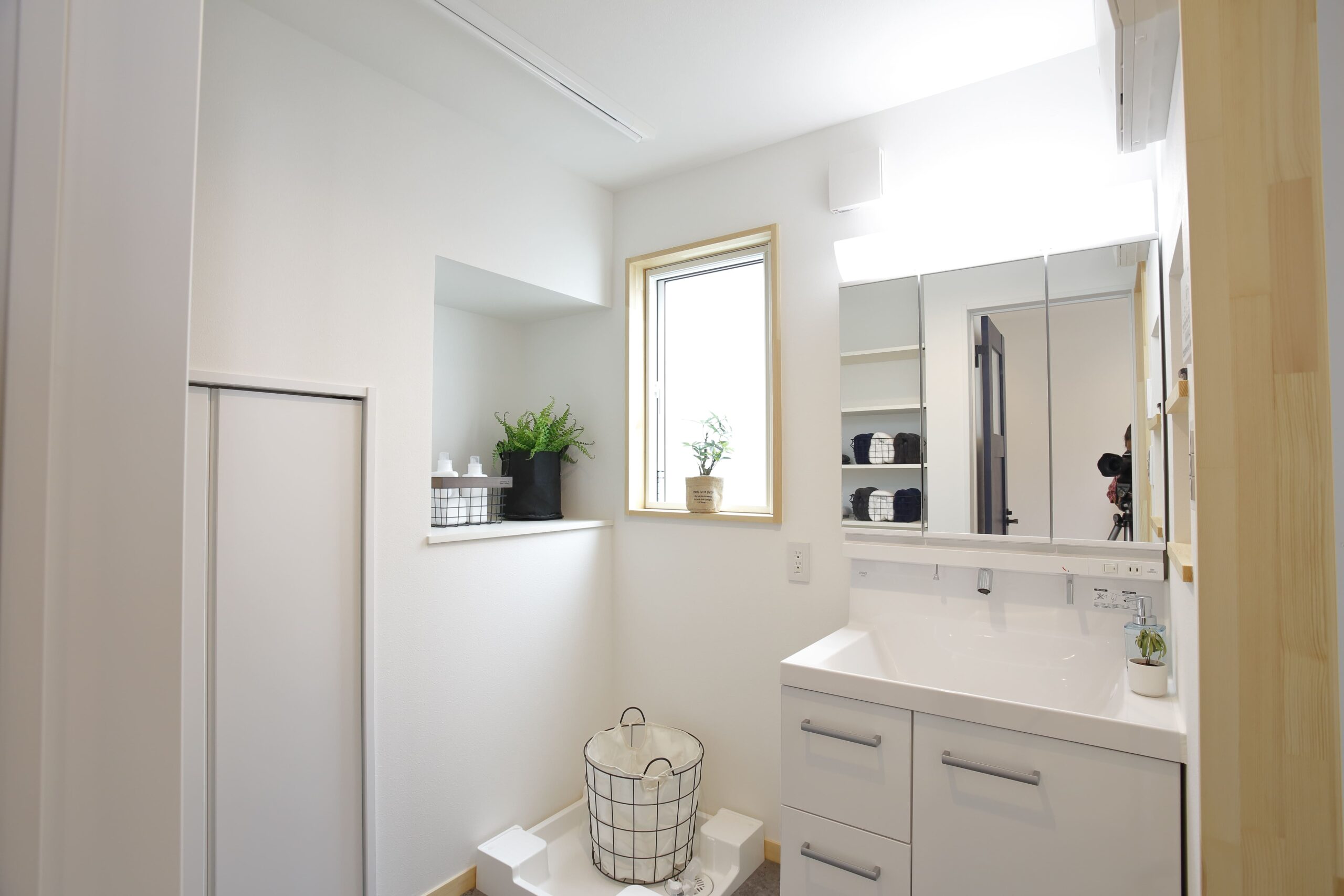 収納棚を備えた洗面室は、日常の使いやすさに配慮。明るい光が入り、家事も快適にこなせるシンプルなデザインです。