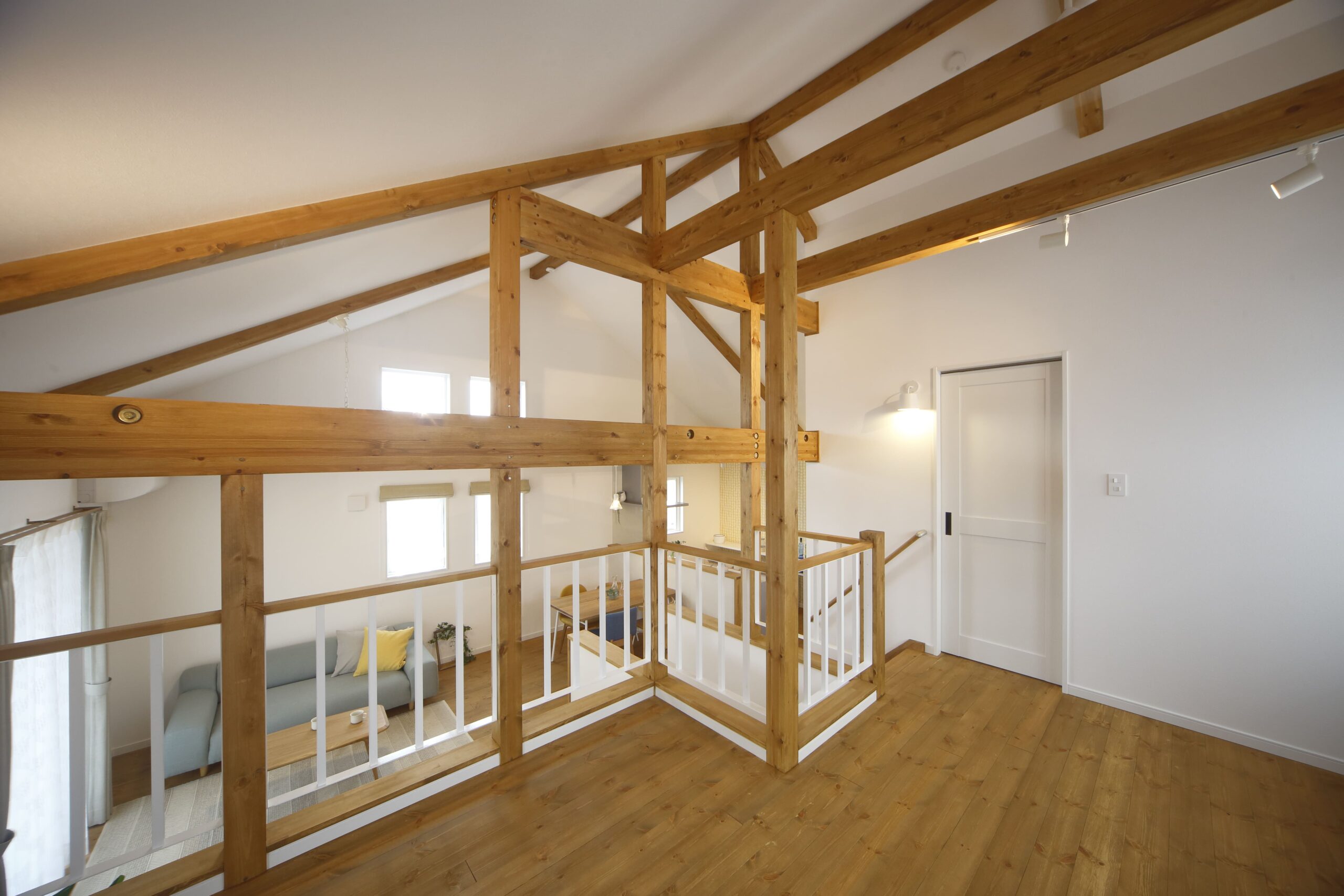 スキップフロアならではの立体的なつながりが心地よい空間。吹き抜けの開放感と木の梁が北欧インテリアを引き立て、家族の気配を程よく感じられる設計です。