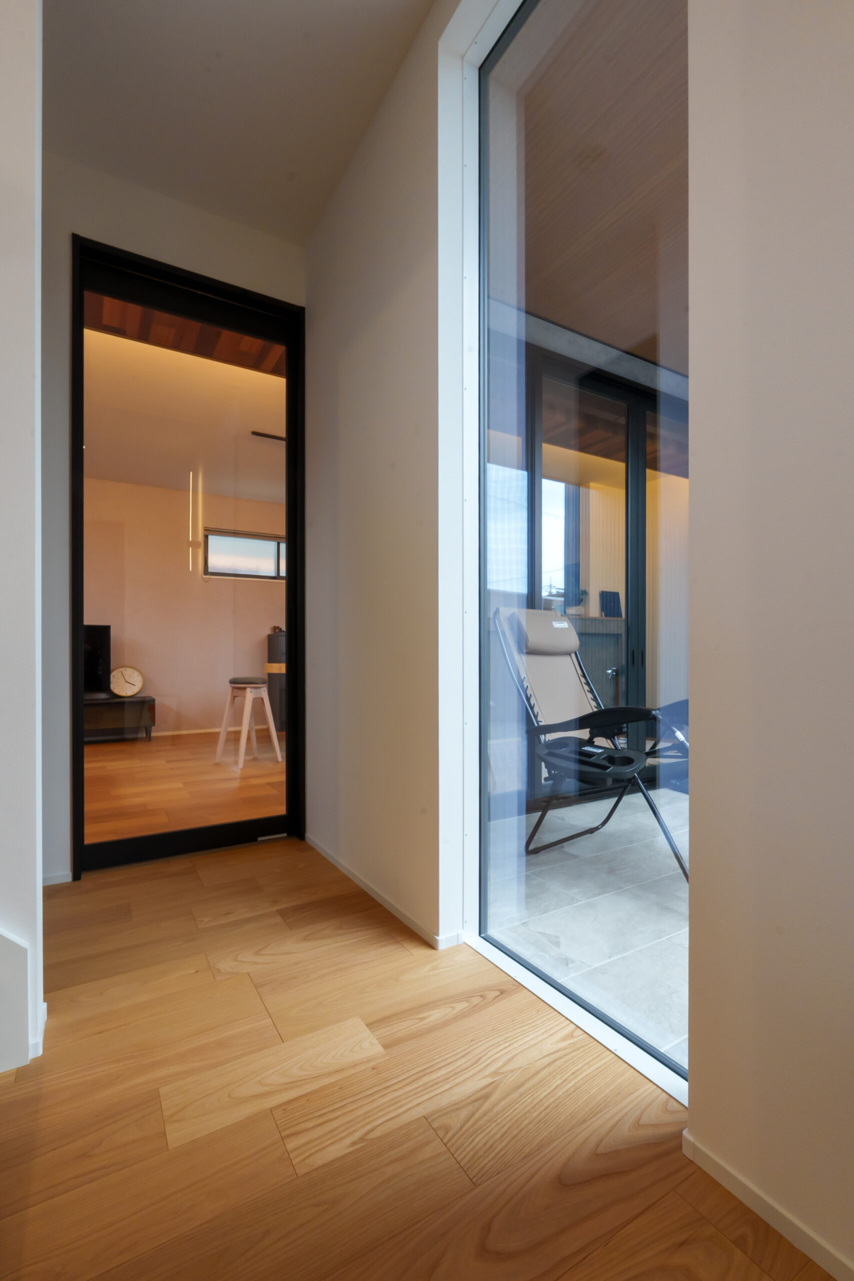 玄関ホールのFIX窓は、階段を降りてきたときに視線が正面テラスに抜けるため開放感が増幅