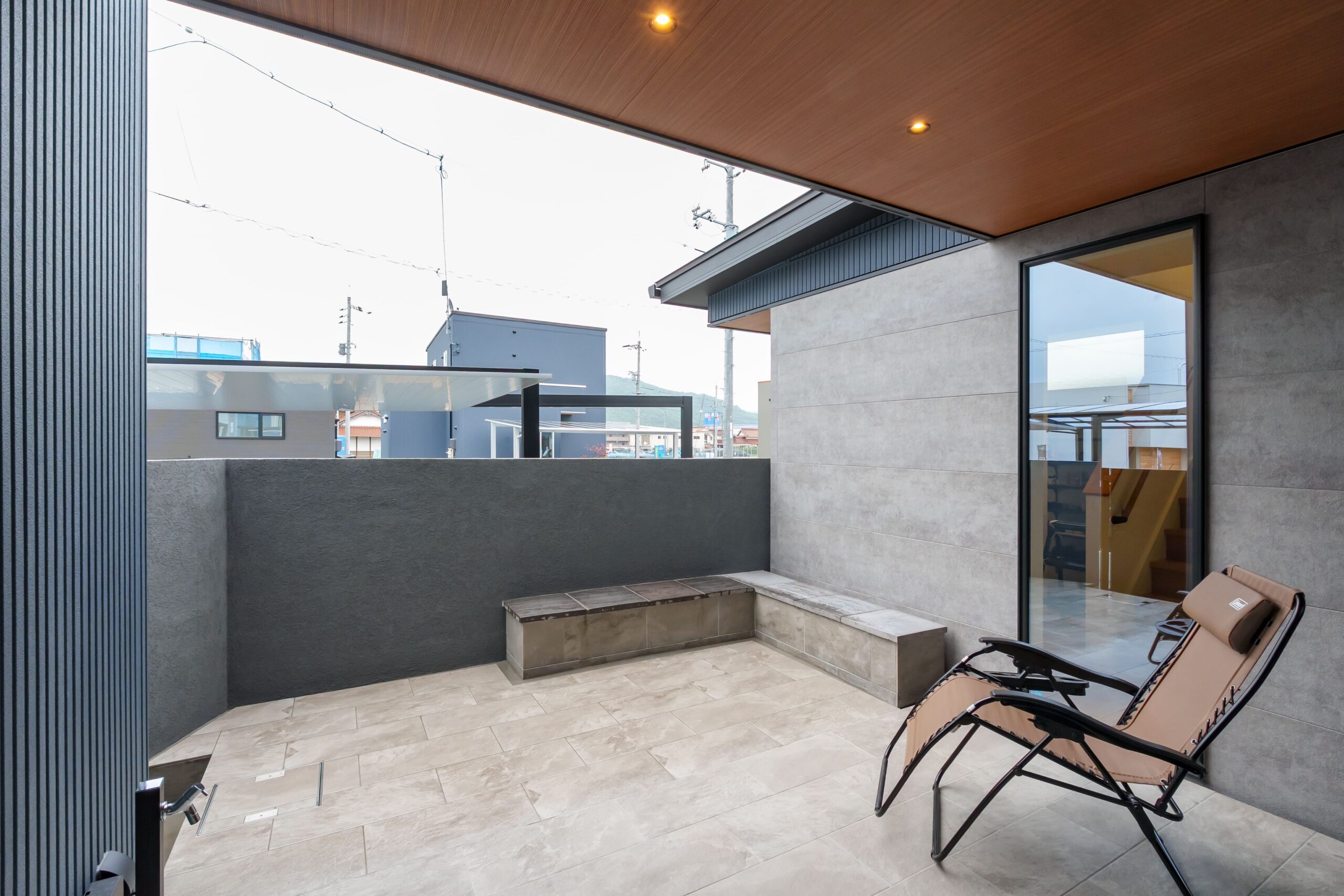 リビングの延長感覚で使える土間はBBQが楽しめるようウッドデッキではなくタイル敷きにし、食器の油汚れを落とすための立水栓も付けた。軒が深いため、窓を開けても屋内に雨が降り込まない。