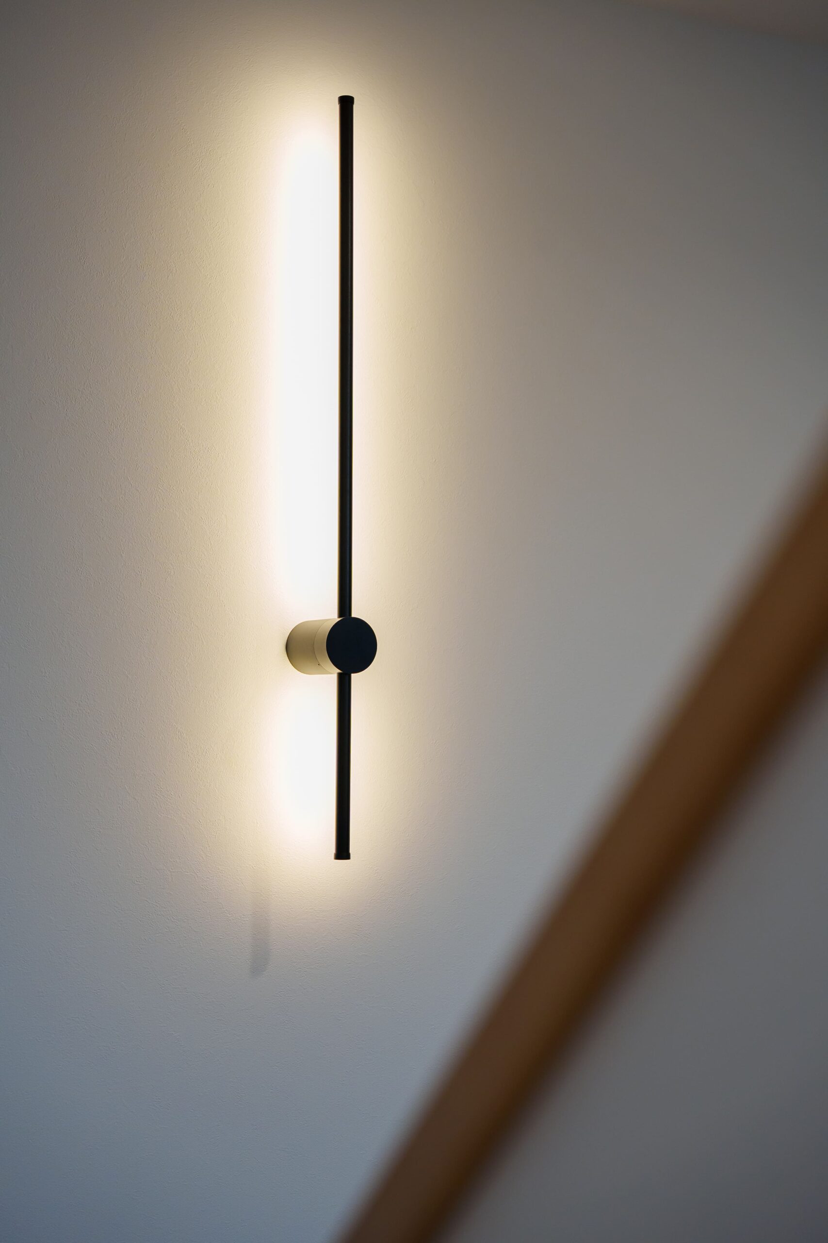 玄関横の壁には、施主支給によるスタイリッシュなデザインが目を惹く間接照明器具を設置。