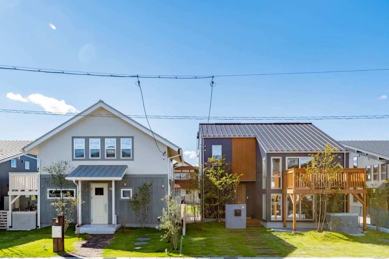 青と木目が映える外観。バルコニーや大開口窓で開放感を演出する住まい。