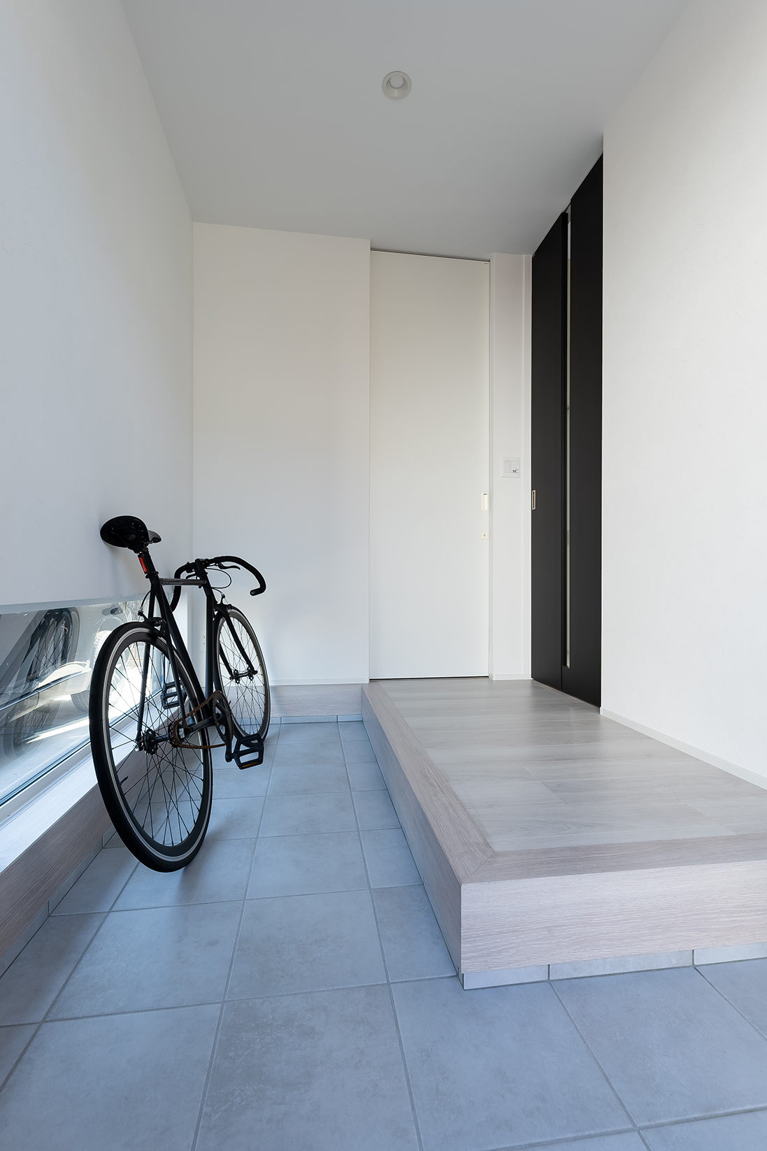 地窓を設けて明るさを確保。自転車が置けるように土間を広くしている。