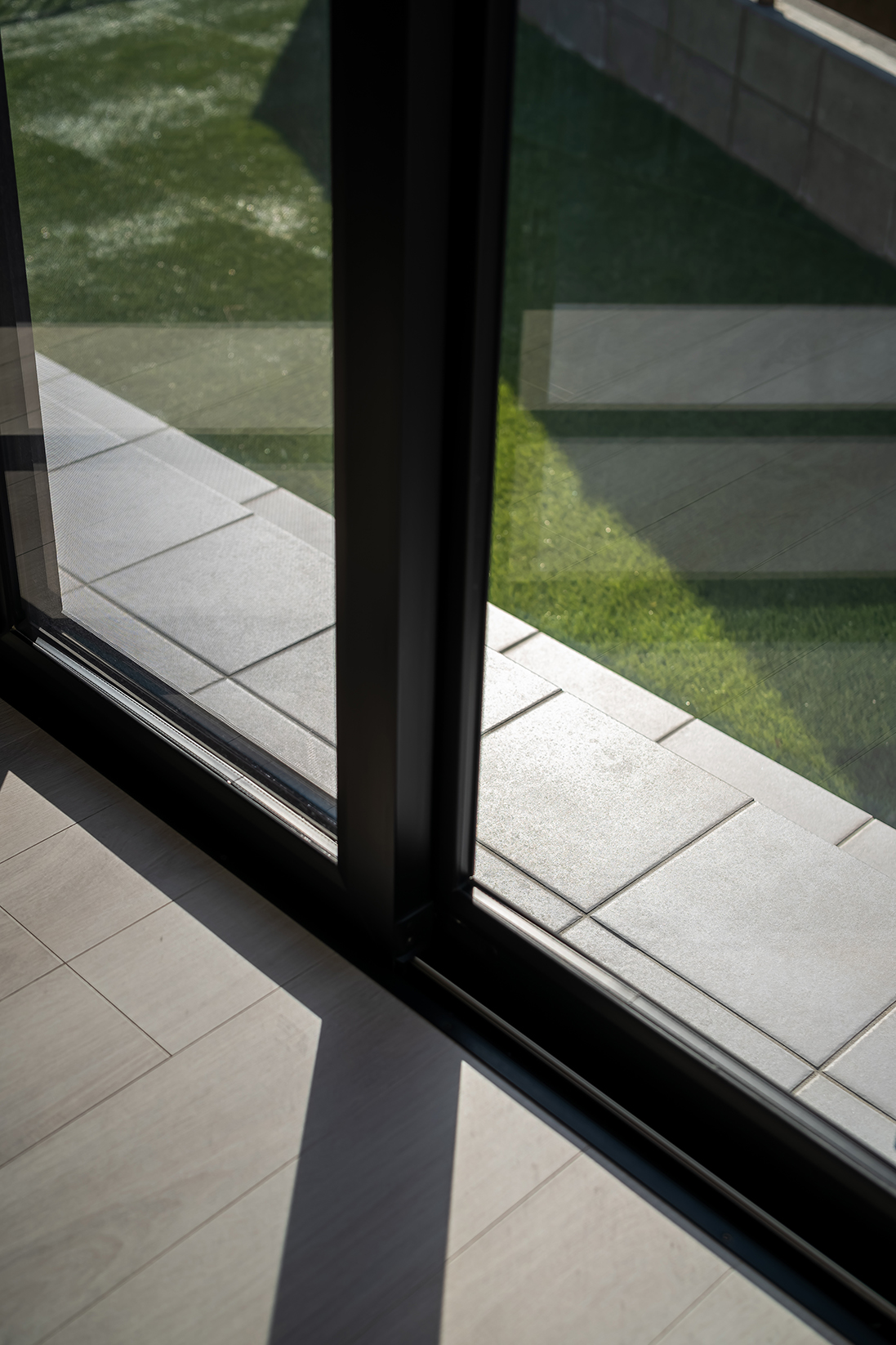 庭へのアプローチには、縁台として使える２段のタイル階段を設置。芝はご主人がDIYで施工。