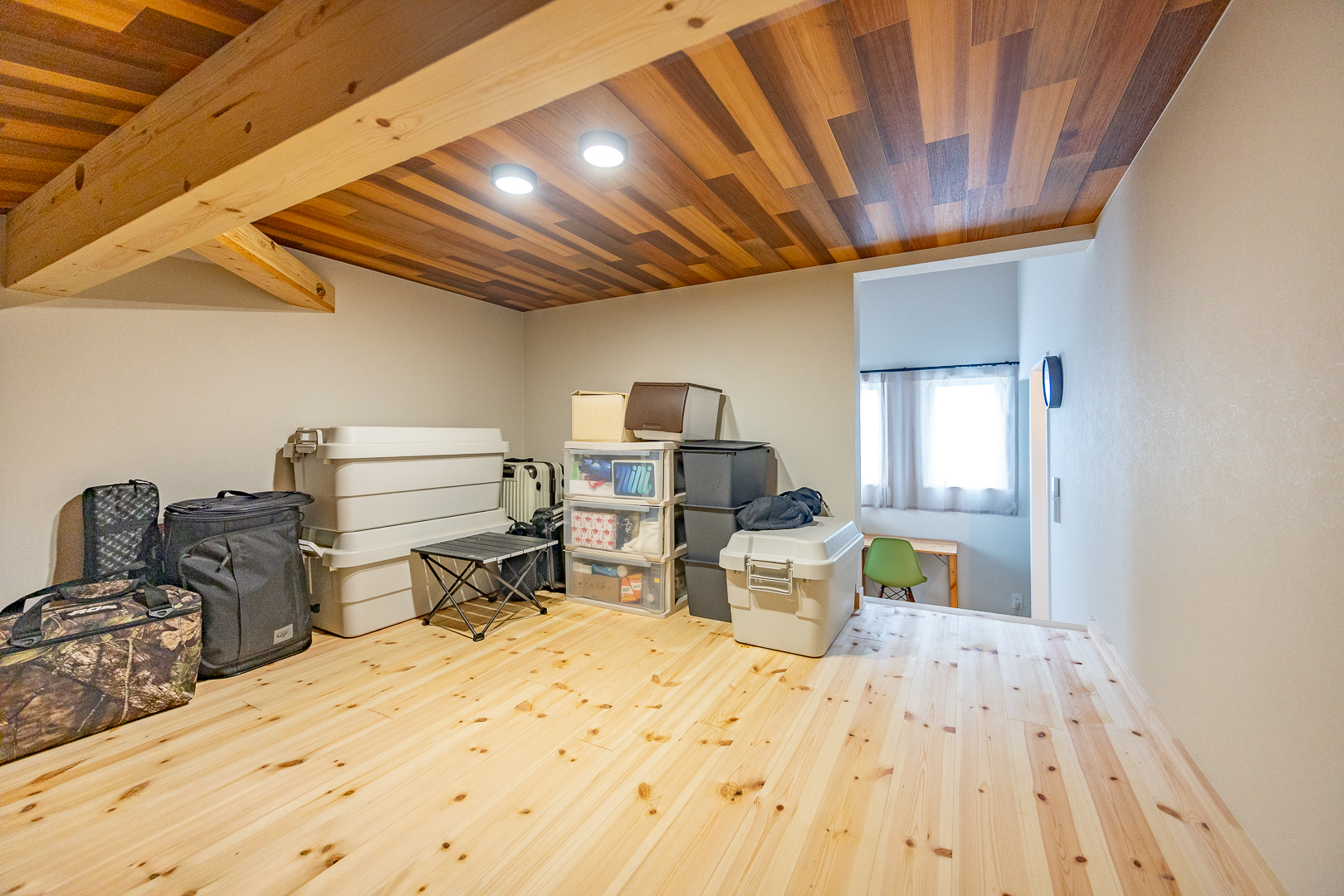 季節の道具やキャンプギアをたっぷり収納できる小屋裏スペース。天井の木目が心地よく、隠れ家のような雰囲気も楽しめる。
