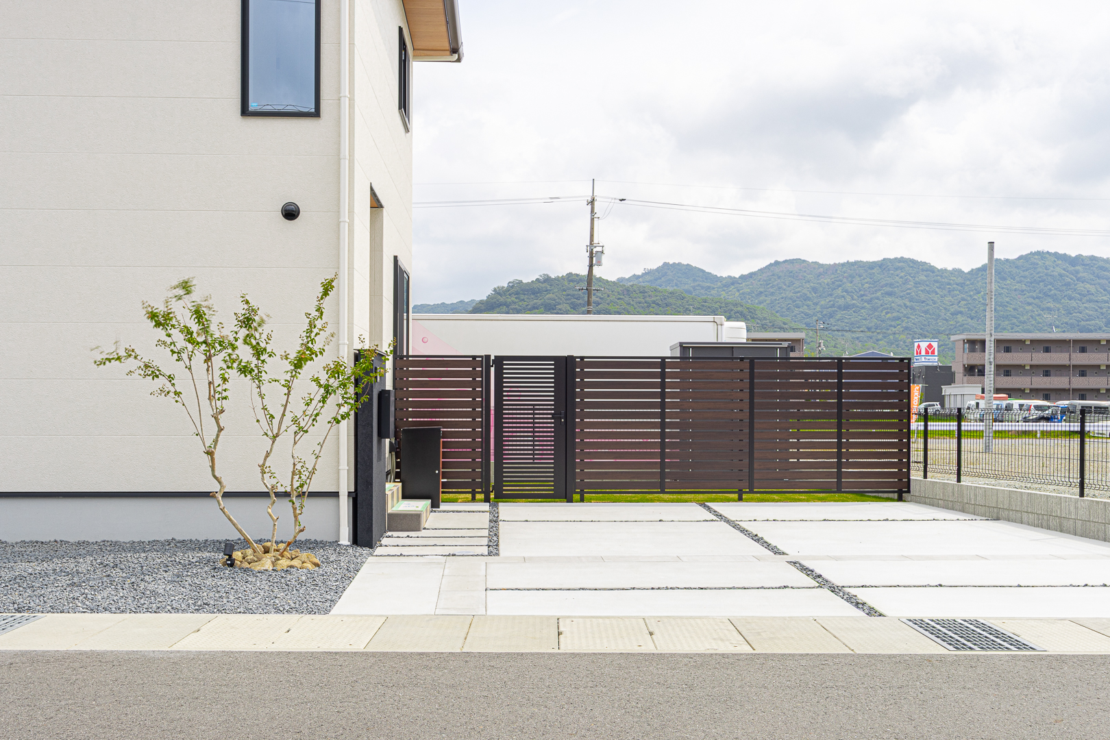 目隠しフェンスがプライバシーを確保しつつ、シンボルツリーが柔らかな表情を添える。