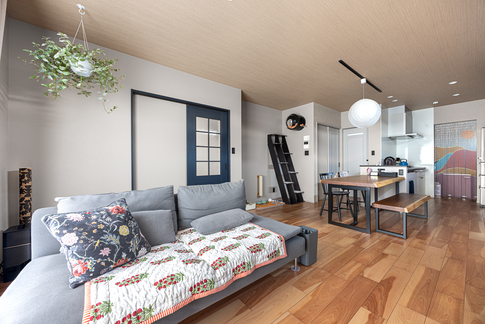 リビングからダイニング、キッチンまで見渡せるゆったりとしたLDK。木目天井が視線を緩やかに導き、インテリアの黒がが空間を引き締める。