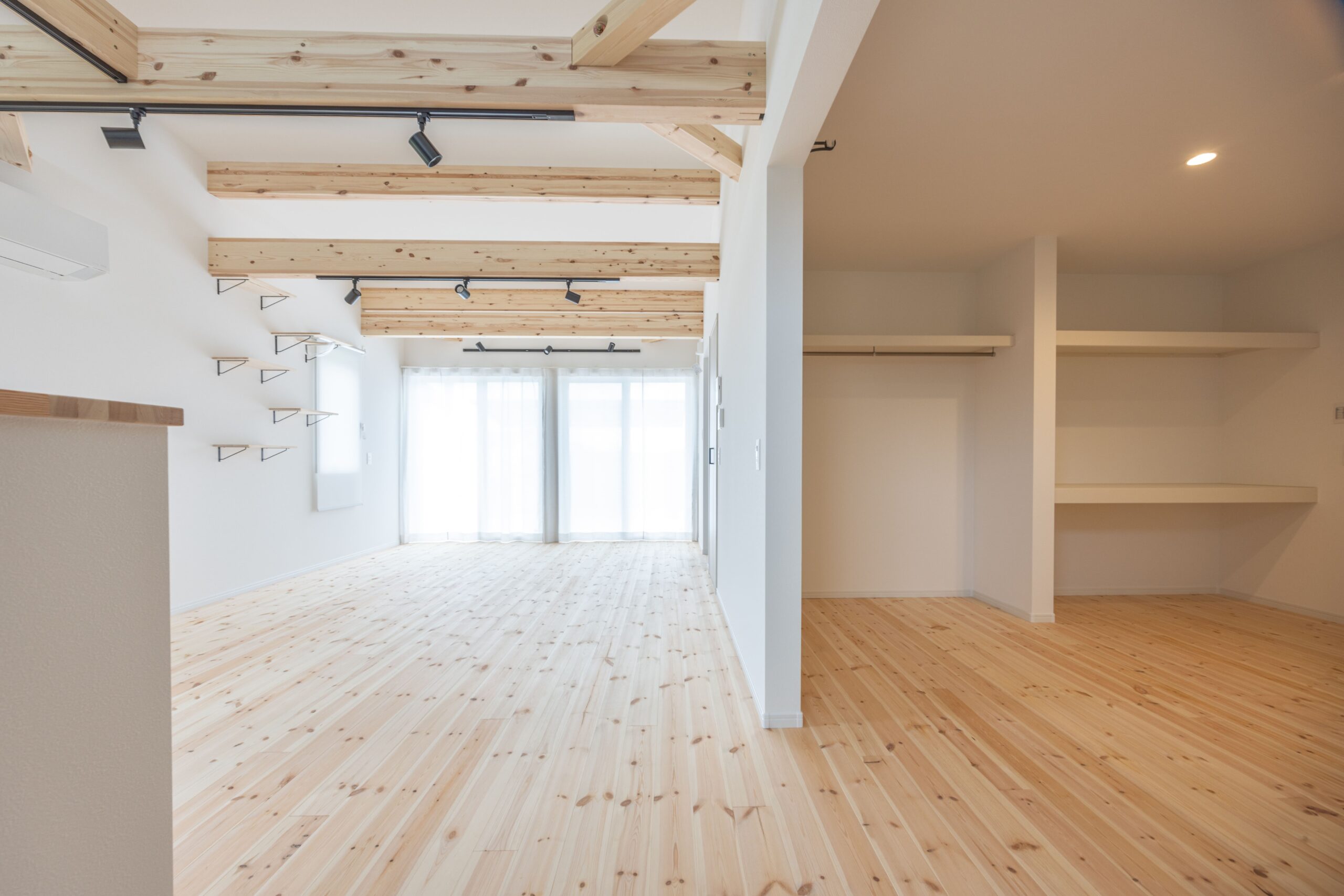 大きな窓から光がたっぷり差し込むリビング。無垢床のぬくもりと、のびやかな広がりを感じられます。