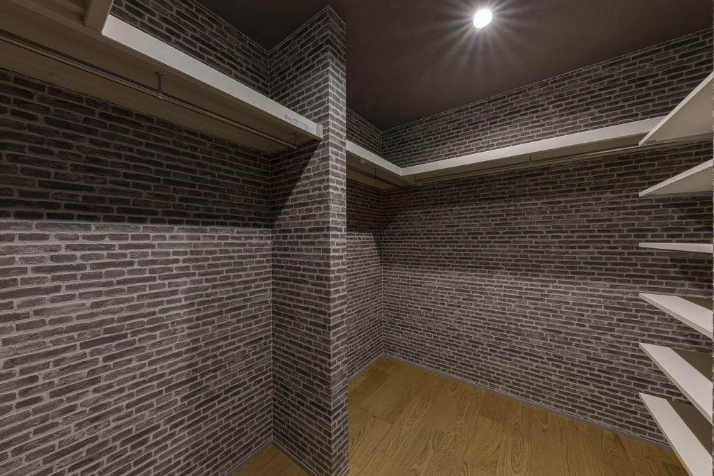 レンガ調のアクセントクロスを前面に採用したウォークインクローゼット。