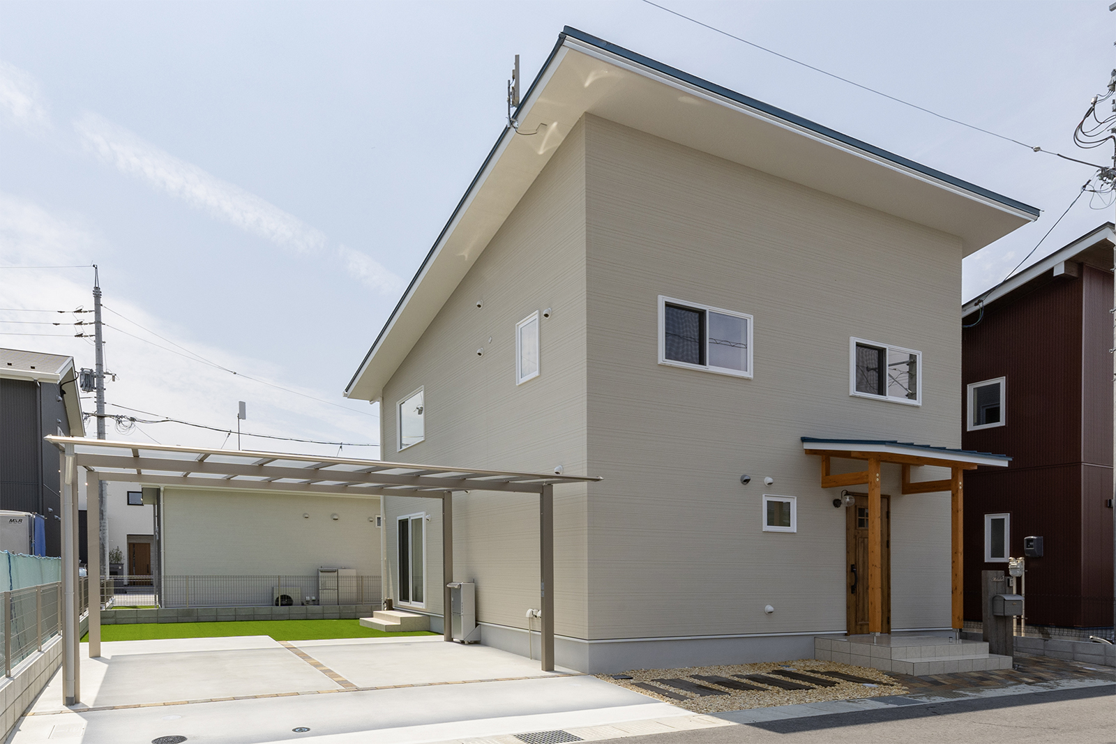 ベージュの外壁を採用したナチュラルハウス。玄関周りにはウッドを採用し素材感が楽しめる。